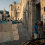 Avignon en famille : rue pavée, Palais des Papes au fond